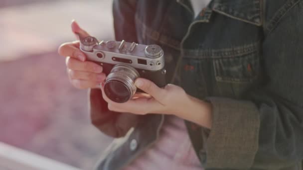Κορίτσι σε διακοπές παίρνει φωτογραφίες του ηλιοβασιλέματος της θάλασσας με μια φωτογραφική μηχανή ταινία — Αρχείο Βίντεο