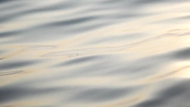 Primer plano, salpicadura de agua, brillo, resplandor del sol en la superficie del mar, puesta de sol en el mar — Vídeo de stock