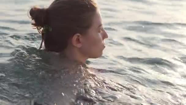 Gün batımında denizde yüzen çekici genç bir kadının portresi, pürüzsüz yüzey, yakın çekim. — Stok video
