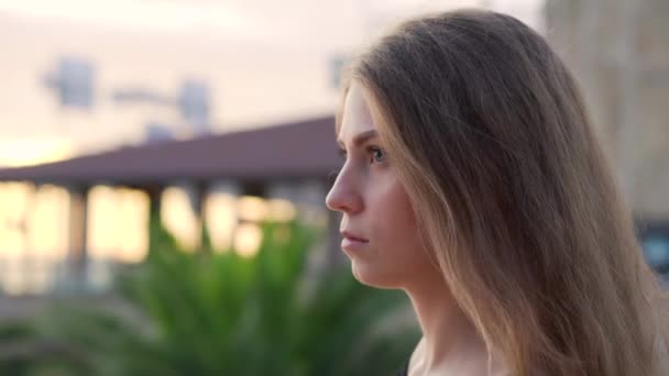 Chica joven en un ambiente romántico está disfrutando de la puesta de sol del mar en la costa — Vídeo de stock