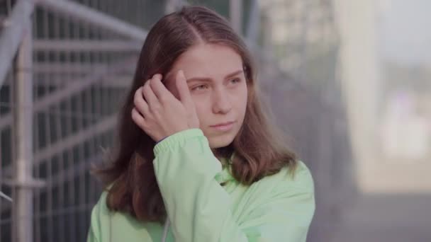 Una ragazza in tuta gira per lo stadio raddrizzandosi i capelli — Video Stock