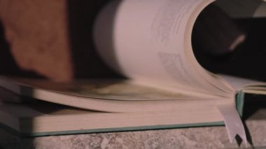 Adam büyük bir antika kitap okuyor.