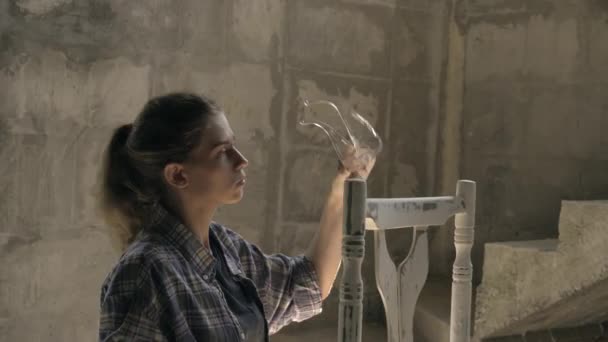 Una giovane ragazza nel suo laboratorio esegue la falegnameria. Riparazione di mobili antichi — Video Stock