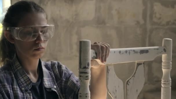 A young girl in his workshop performs carpentry. Repair of antique furniture — Stock Video