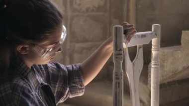 Atölyesindeki genç bir kız marangozluk yapıyor. Antika mobilyaların tamiri