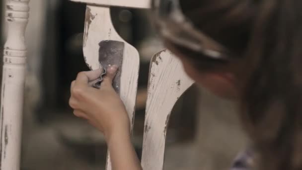 Una joven en su taller realiza carpintería. Reparación de muebles antiguos — Vídeos de Stock