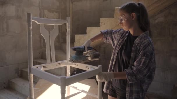 Fille charpentier réparations meubles anciens à l'aide d'une ponceuse — Video