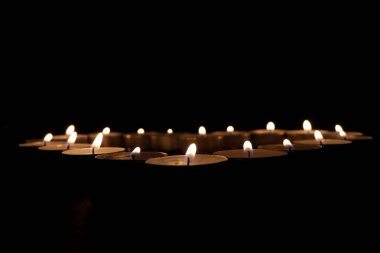 Kalp şeklinde, karanlıkta küçük mumlar.