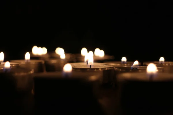 Many small candles in the dark