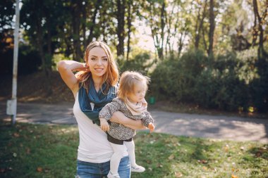 Genç bir aile parkta yürüyor.