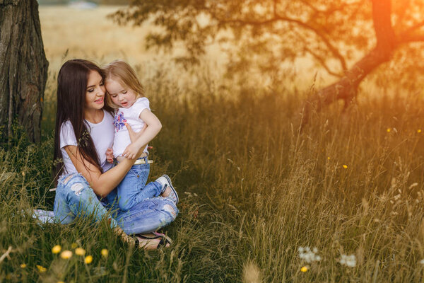 child near tree with mom