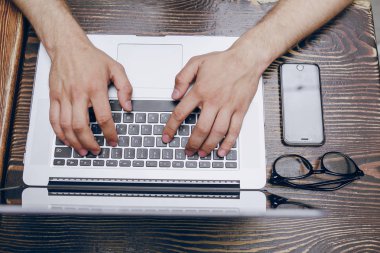 Kafede dizüstü bilgisayarı olan bir adam.