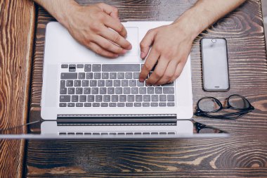 Kafede dizüstü bilgisayarı olan bir adam.