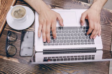 Kafede dizüstü bilgisayarı olan bir adam.