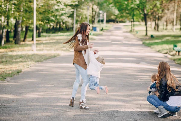 Giovani famiglie passeggiano nel parco — Foto Stock