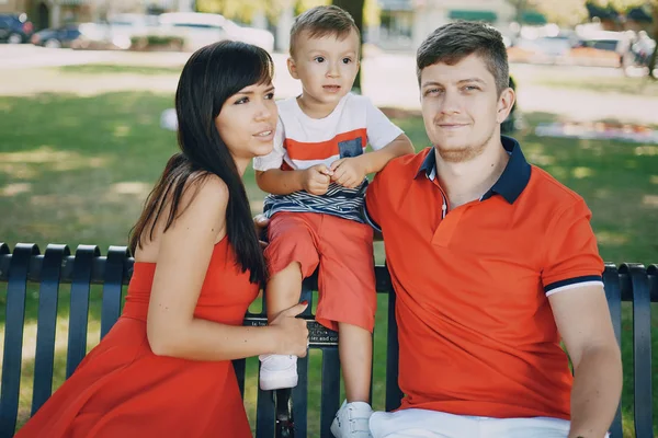 Hermosa familia en rojo caminando por la calle y el Parque — Foto de Stock