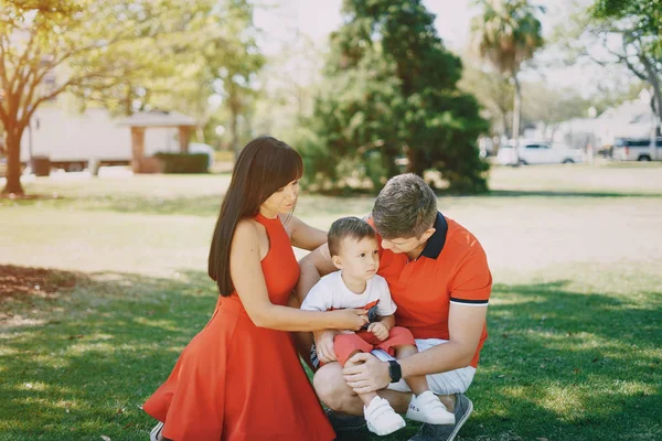 Belle famille en rouge marchant dans la rue et le parc — Photo