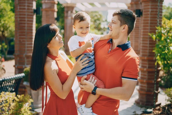 Hermosa familia en rojo caminando por la calle y el Parque — Foto de Stock