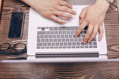 Kafede dizüstü bilgisayarı olan bir adam.