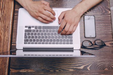 Kafede dizüstü bilgisayarı olan bir adam.