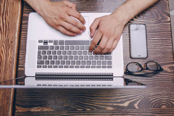 Kafede dizüstü bilgisayarı olan bir adam.