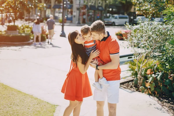 Vacker familj i rött gående längs gatan och Park — Stockfoto