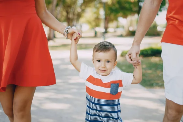 Hermosa familia en rojo caminando por la calle y el Parque — Foto de Stock