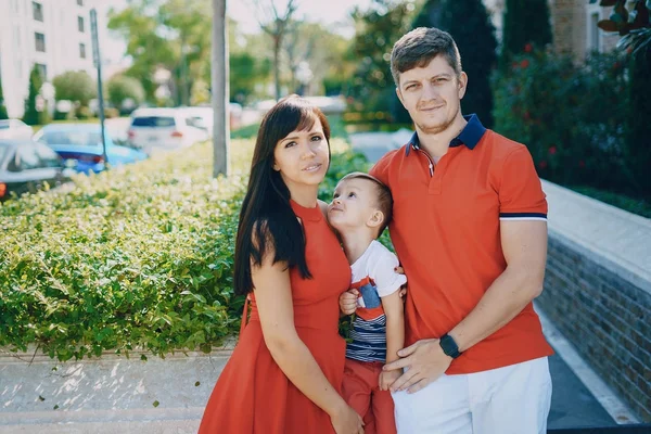 Hermosa familia en rojo caminando por la calle y el Parque — Foto de Stock