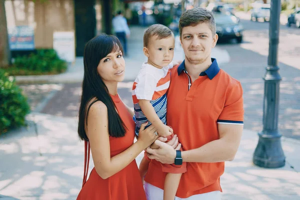 Hermosa familia en rojo caminando por la calle y el Parque — Foto de Stock