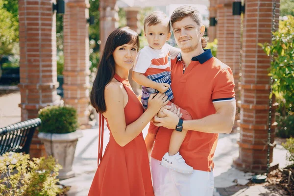 Prachtige familie in rood onderaan de straat en het Park lopen — Stockfoto