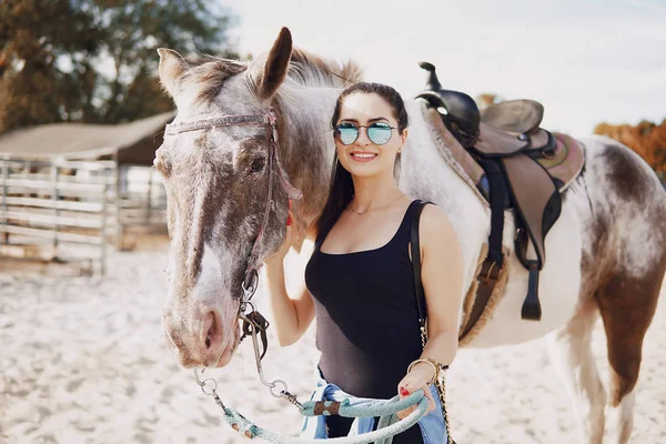 Chica preparándose para montar a caballo — Foto de Stock