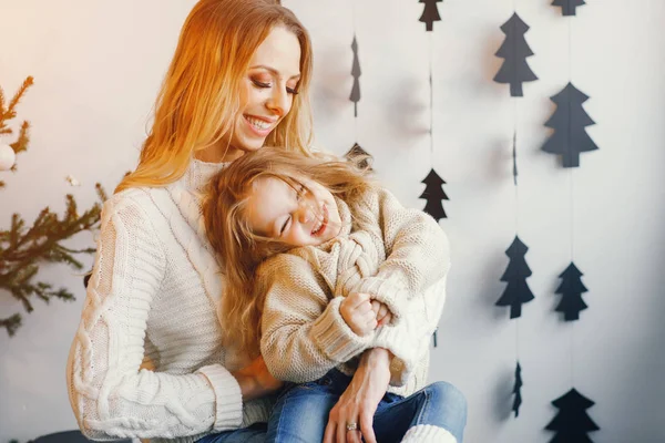 Madre e hija sentadas por decoraciones navideñas — Foto de Stock