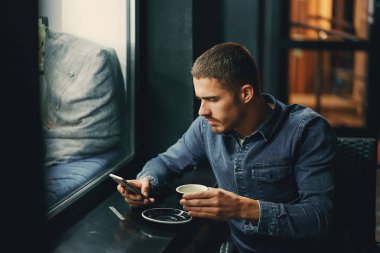 Restoranda telefon kullanan bir adam.