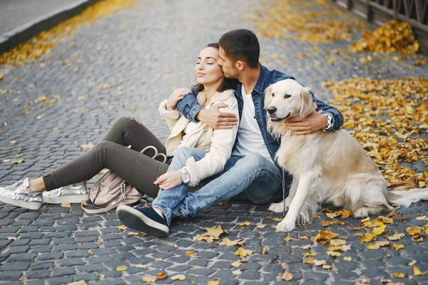 Coppia che porta a spasso il cane in una giornata autunnale soleggiata — Foto Stock