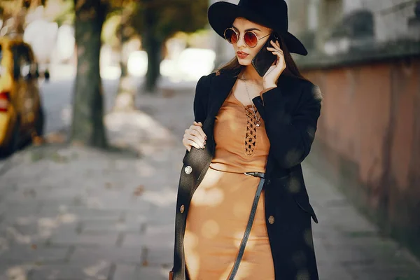 Menina elegante andando pela cidade enquanto usa seu telefone — Fotografia de Stock