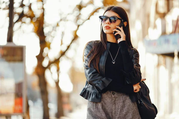 Menina elegante andando pela cidade enquanto usa seu telefone — Fotografia de Stock