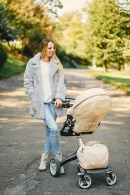 genç anne bebek arabasını iterek