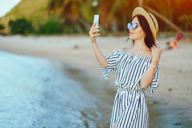 Kız telefonunu kullanarak plaj boyunca uyanma