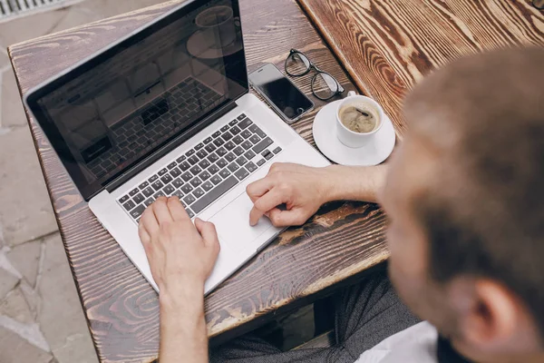 Homme avec ordinateur portable dans le café — Photo