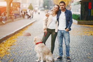 Çiftler güneşli bir sonbahar gününde köpeklerini gezdirirler.
