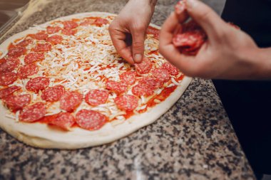 Mutfakta şef pizza hazırlıyor.