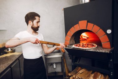 Mutfakta şef pizza hazırlıyor.