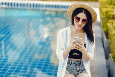 Esmer kız telefonunu kullanıyor.