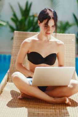 Havuz kenarında çalışan esmer kız.