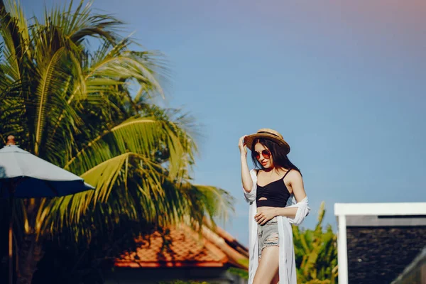 Menina morena relaxante na piscina — Fotografia de Stock