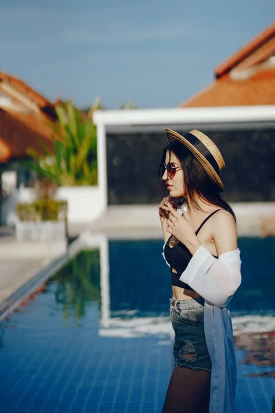 Menina morena relaxante na piscina — Fotografia de Stock