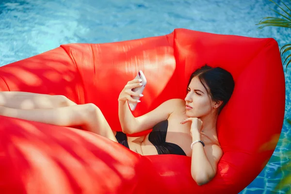 여 자가 사용 하 고 수영장에서 그녀의 전화 통화 — 스톡 사진