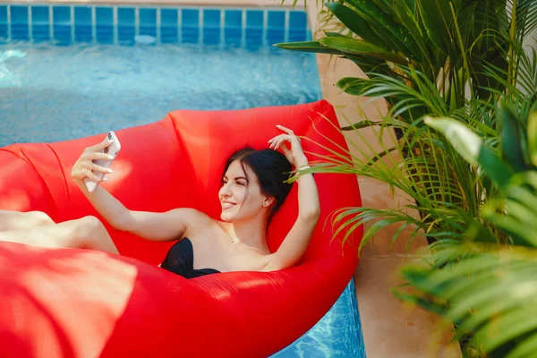 여 자가 사용 하 고 수영장에서 그녀의 전화 통화 — 스톡 사진