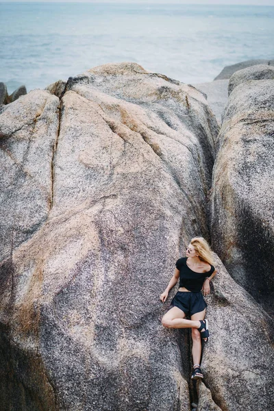 Ragazza bionda seduta su una formazione rocciosa — Foto Stock