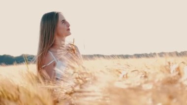 Sarı saçlı, beyaz elbiseli, buğday kulaklı bir kadın.